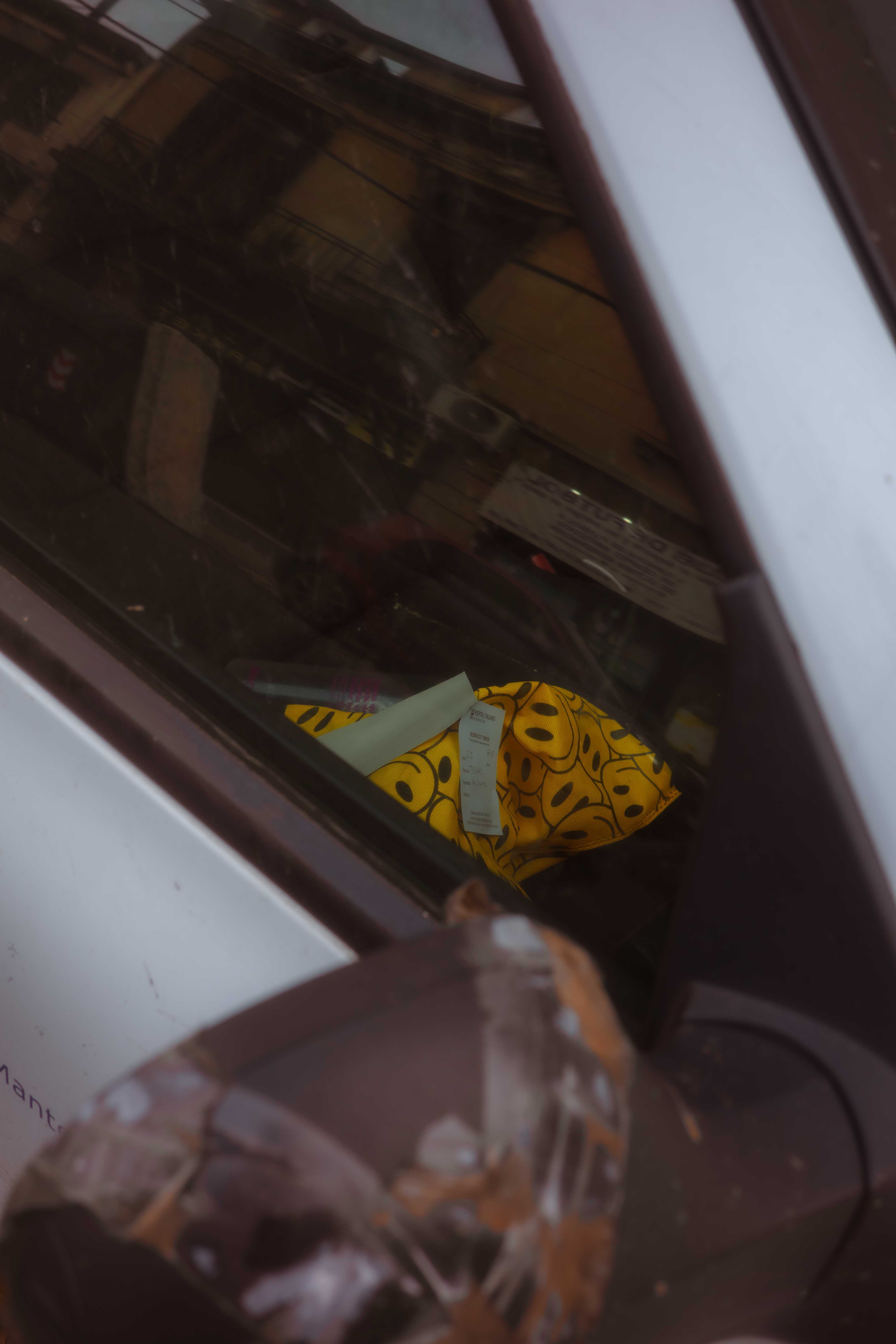 Una figura amarilla de dibujos animados dentro de un auto, junto a un espejo lateral deteriorado.