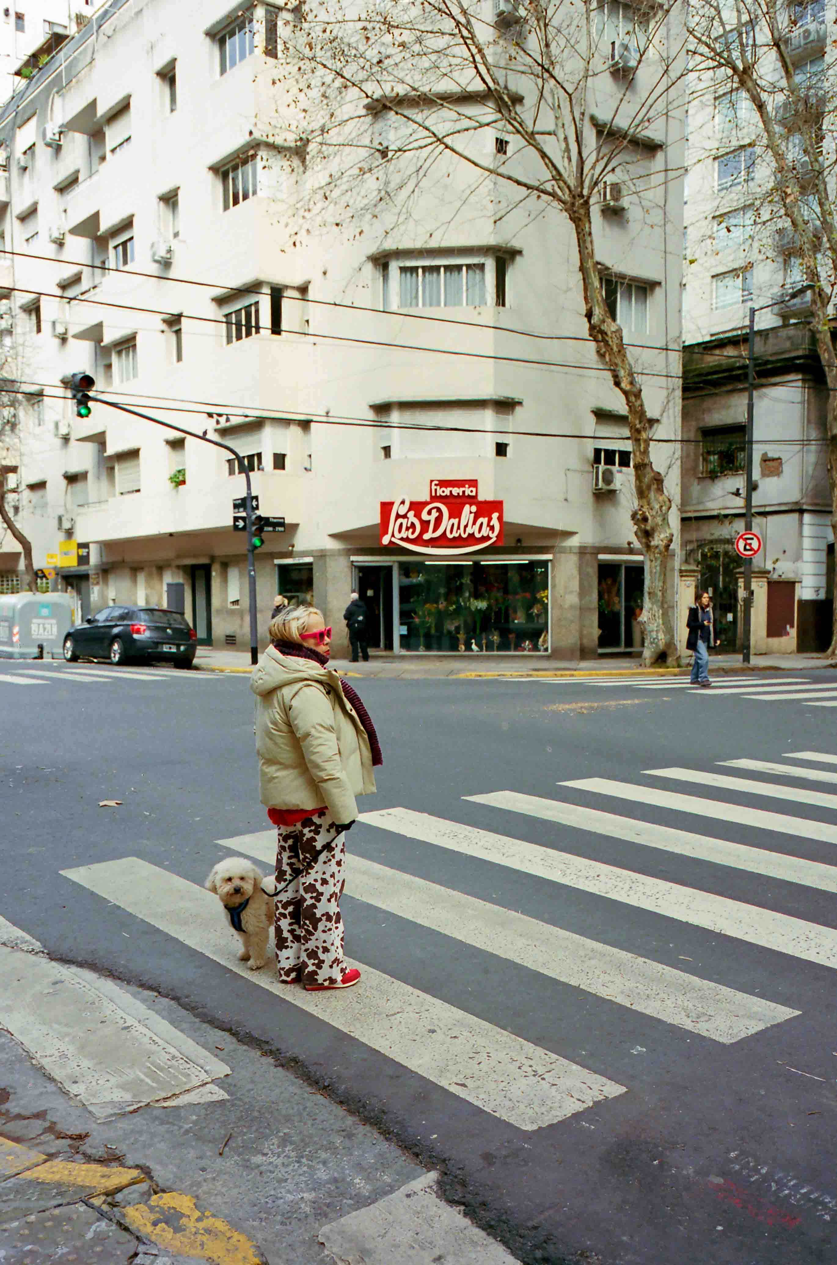 Una señora paseando a su perro con un pantalón con trama de dálmata