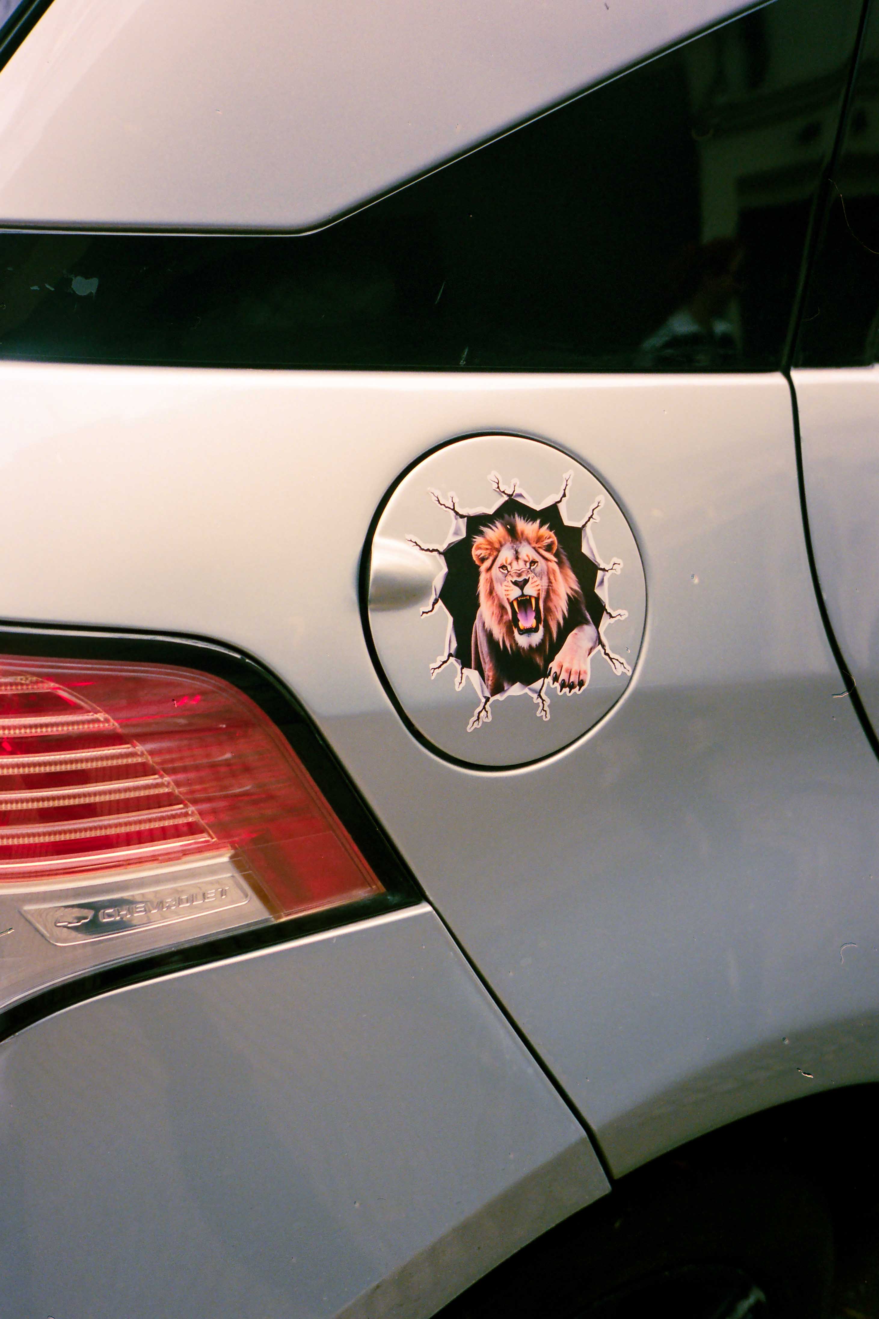 Sticker de león sobre depósito de nafta de auto