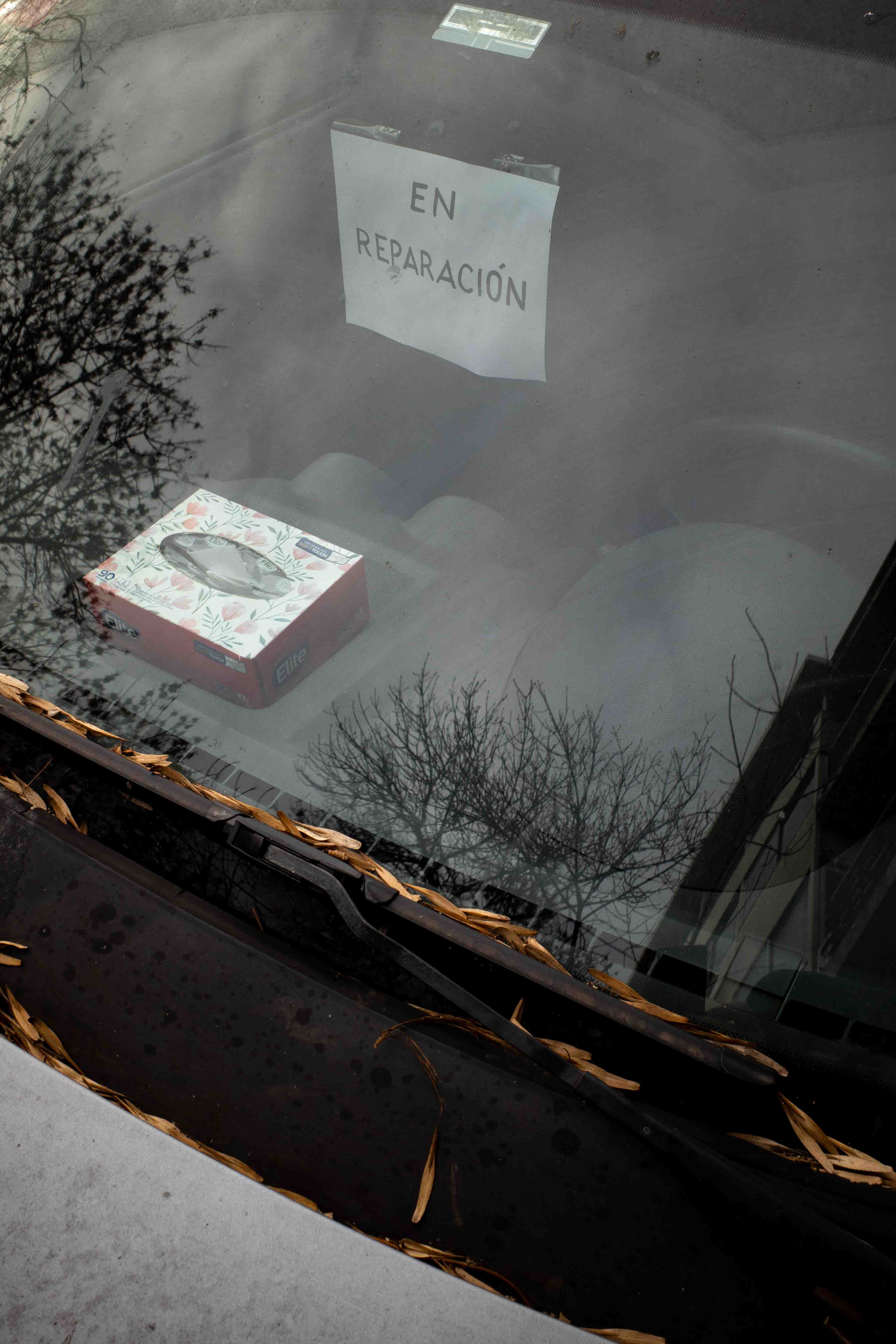 Cartel de en reparación dentro de auto