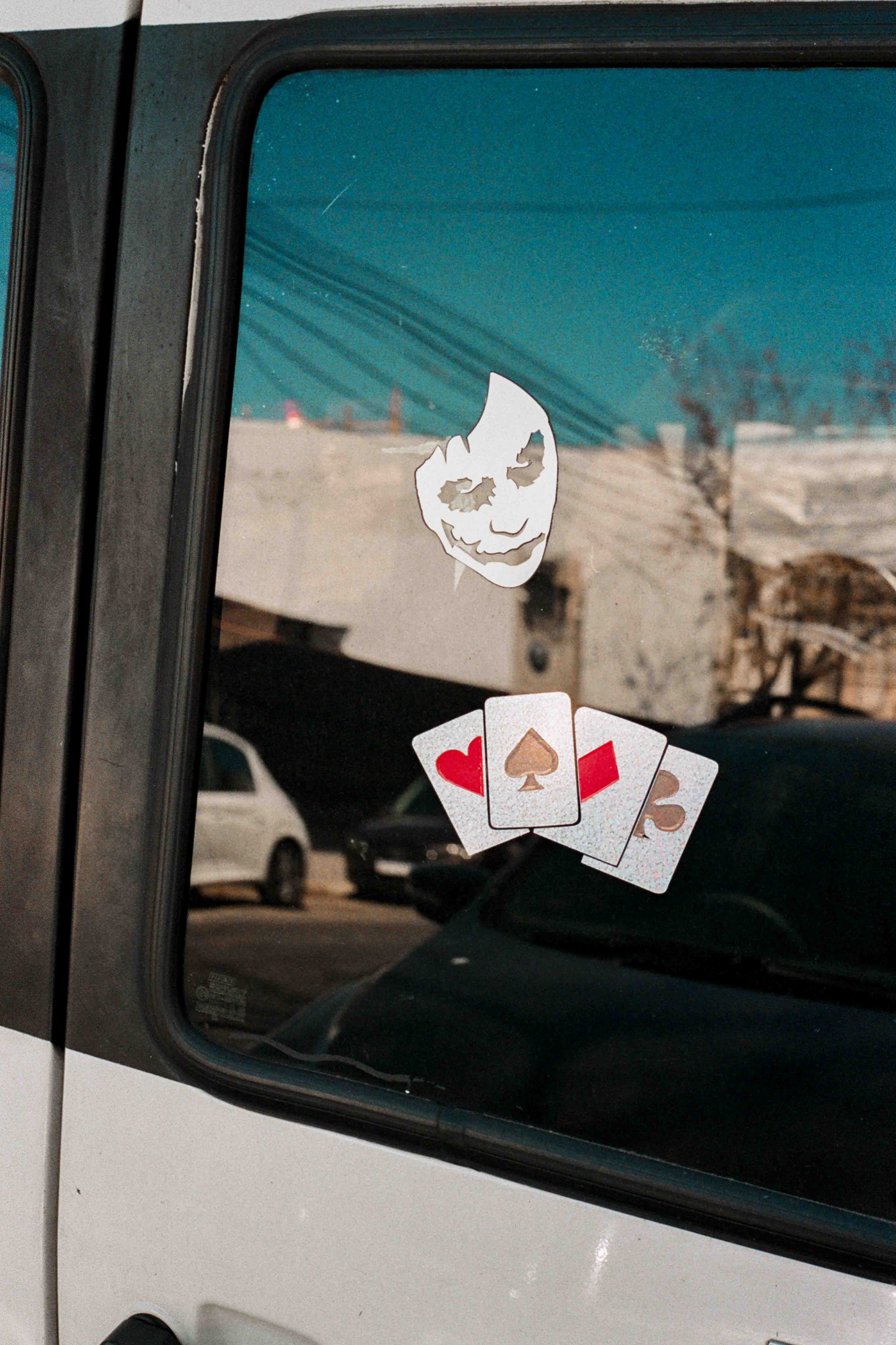 Sticker del joker y cartas de poker sobre vidrio de auto